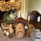 A mushroom house made from natural gourds. The original gourd stem on the top. A "Squirl Cottage" house sign hangs on the side. 